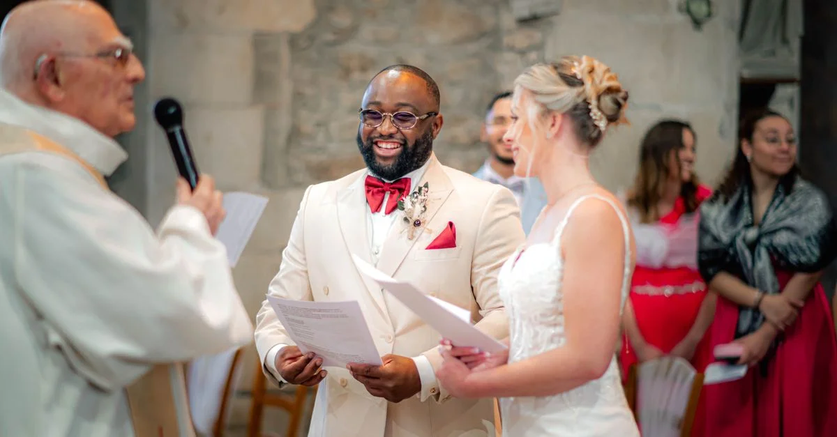 Une cérémonie de mariage joyeuse à l'intérieur d'une église en pierre historique, capturant la mariée, le marié et l'officiant.