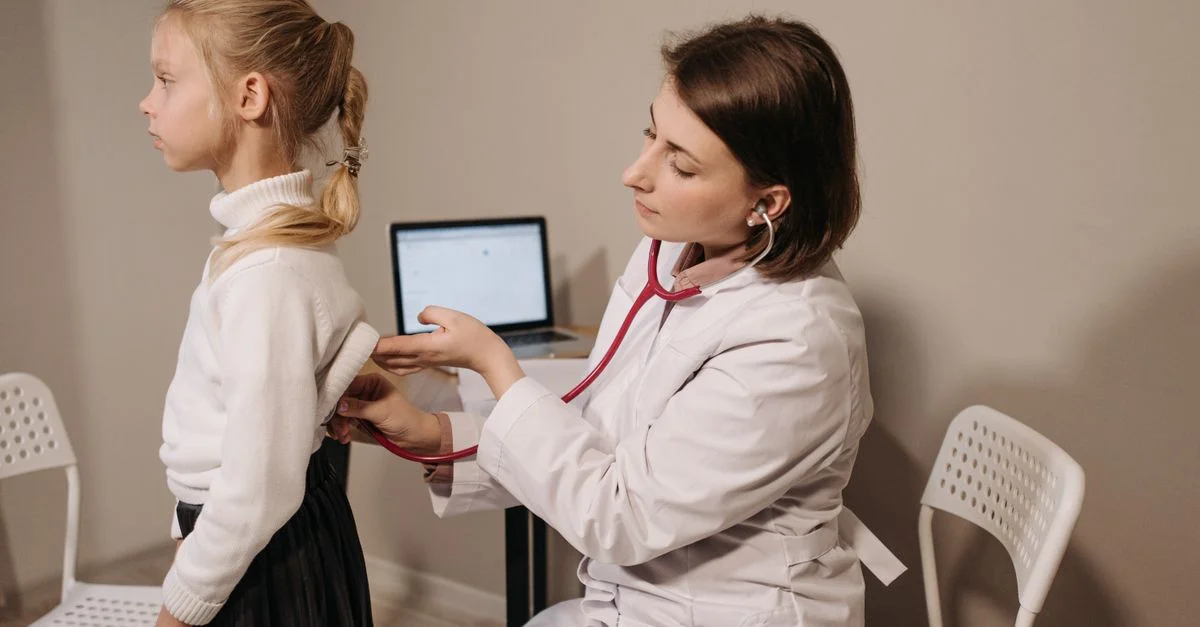 Un médecin utilise un stéthoscope lors de l'examen médical d'un enfant dans un cabinet.